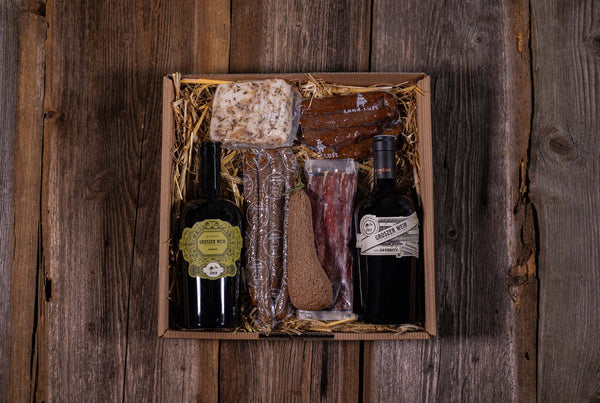 Premium Geschenkkorb mit Rotwein, Weißwein, Lardo, Knochenschinken, Fenchelsalami, Leberfinger Handwürste und  Pfefferbeißer verpackt im Geschenkkarton verpackt