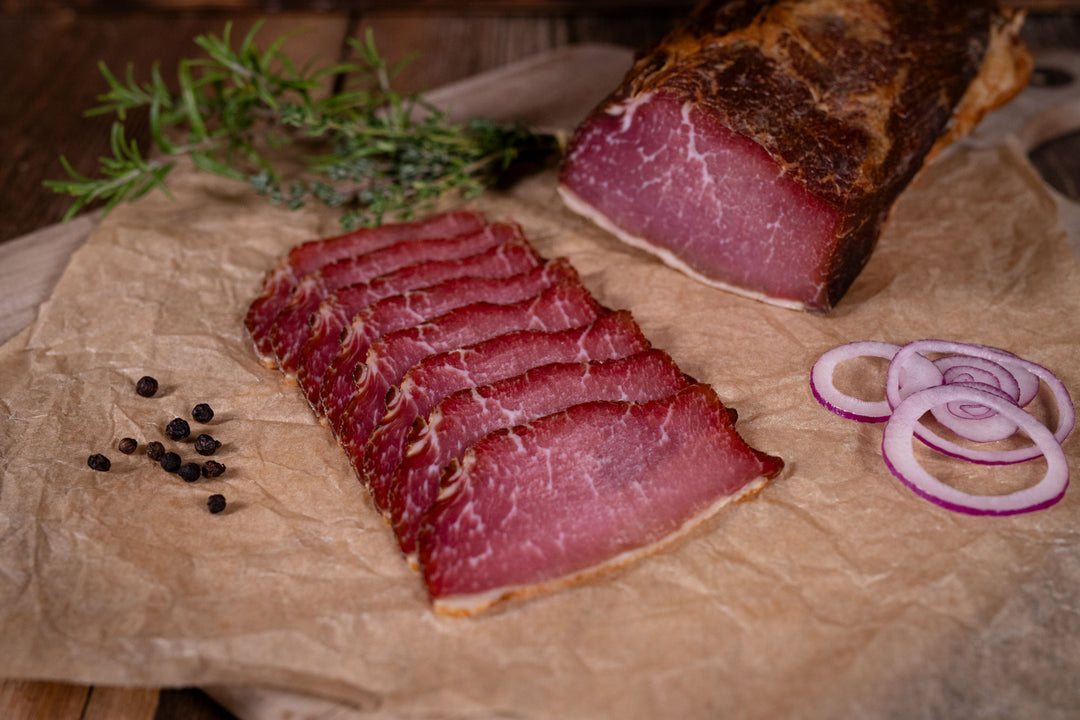 Auf dem Bild ist Rohgeräucherter Rücken – Lachsschinken aufgeschnitten, vom Weideschwein aus 100 % Weidehaltung in Bioqualität. Ideal für Brotzeit, Wurstplatten oder als herzhafter Snack.