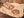 Auf dem Bild ist unsere Rosé Salami zu sehen. Im Stück und ein Paar Scheiben aufgeschnitten.